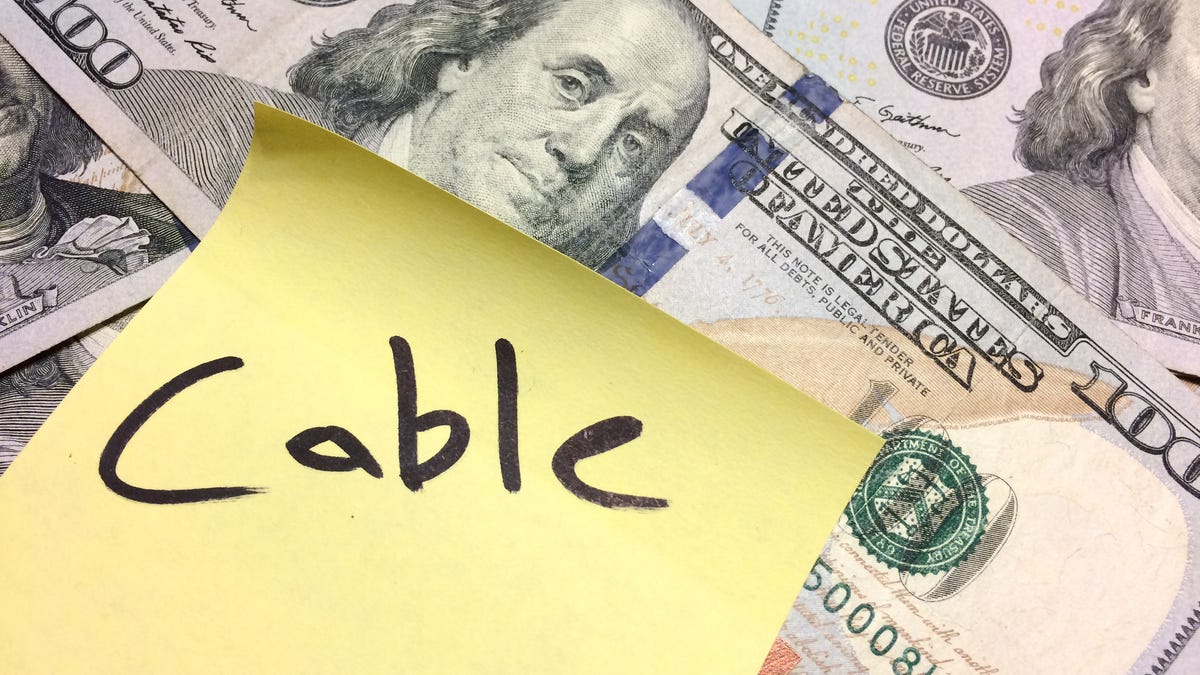 US paper money and a sticky note with the word "cable"