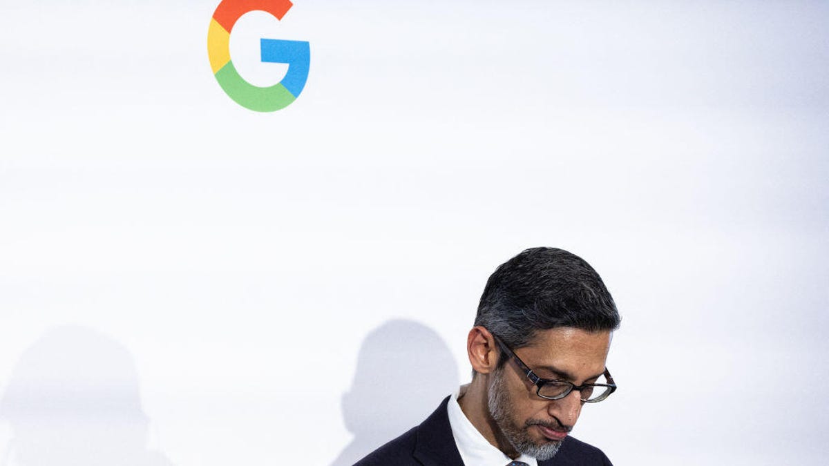 Sundar Pichai looking down, below a Google G logo