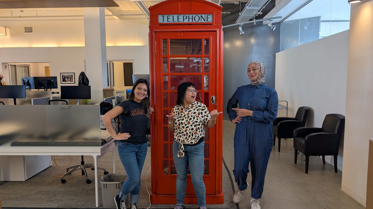 The Add Me feature, shot on the Pixel 9 Pro XL, places three people together by a red telephone booth