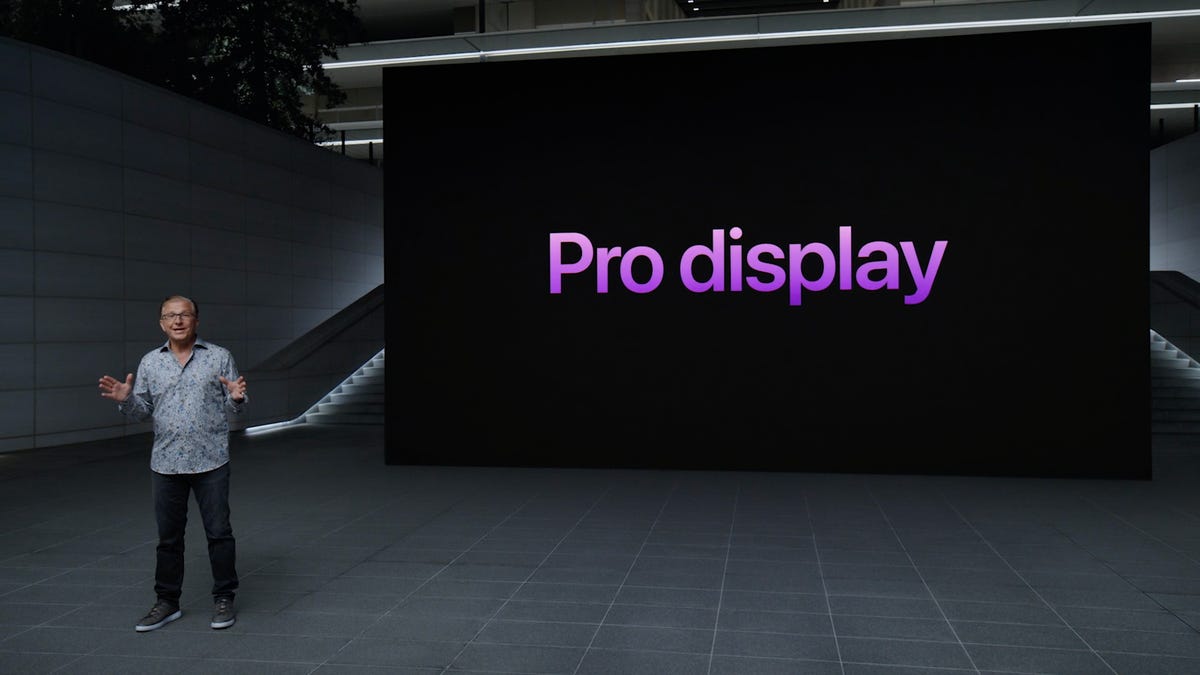 An Apple event presenter in front of a screen that says "Pro display"