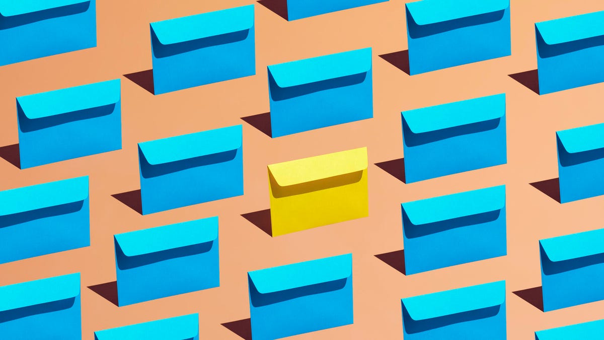 A group of blue envelopes laid in a pattern on a colorful background where one envelope is yellow.