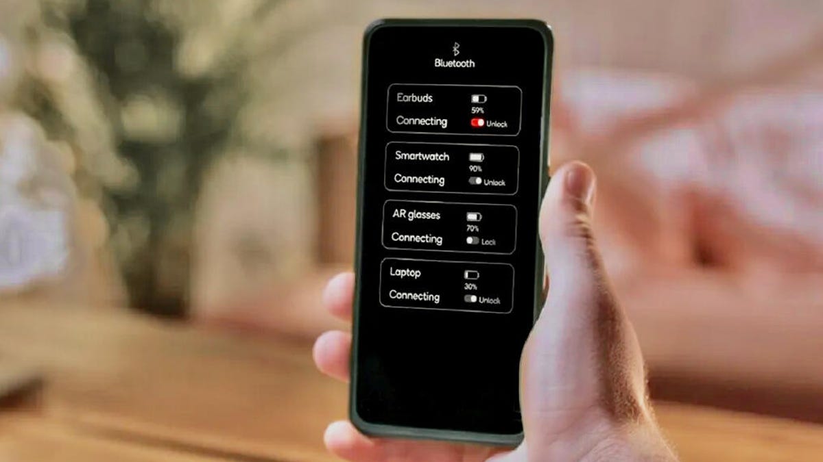 A phone is held in hand, and on the screen are a list of devices it's connected to, like earbuds, a smartwatch and a laptop.