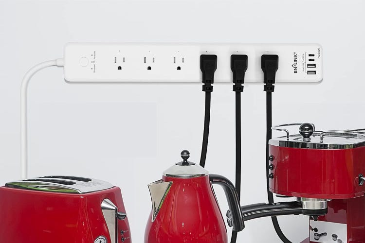 A white BN-Link power strip hangs on a wall above red appliances.