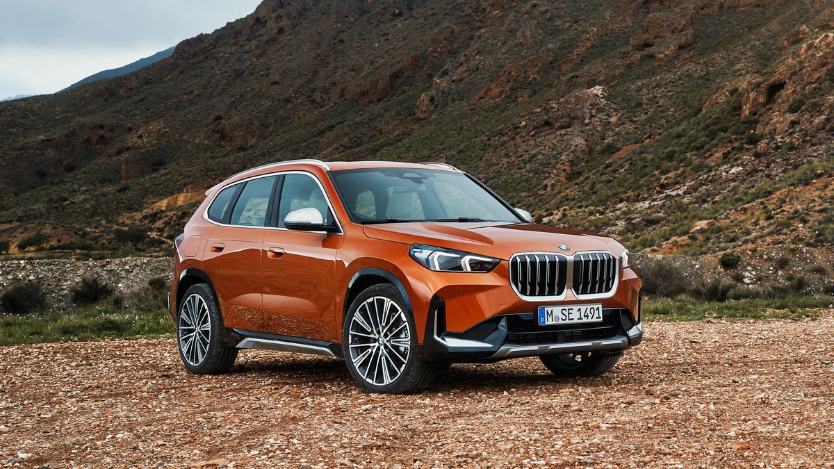2023 BMW X1 parked on a dirt road beside a rocky hill