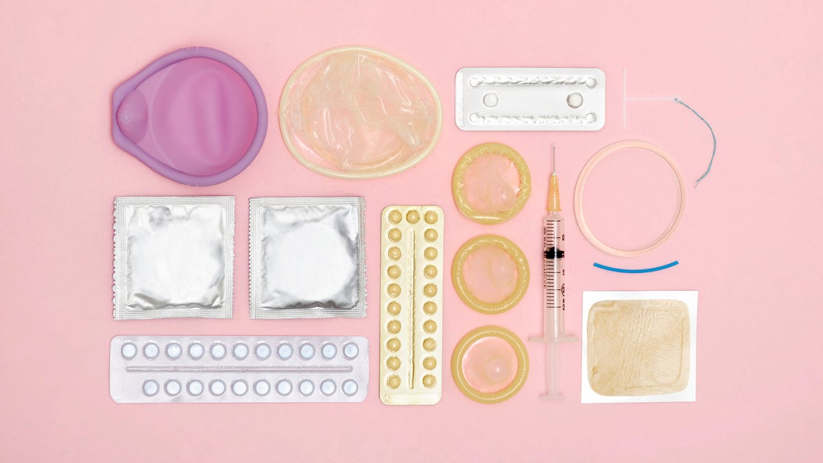 Different forms of birth control against a light pink background