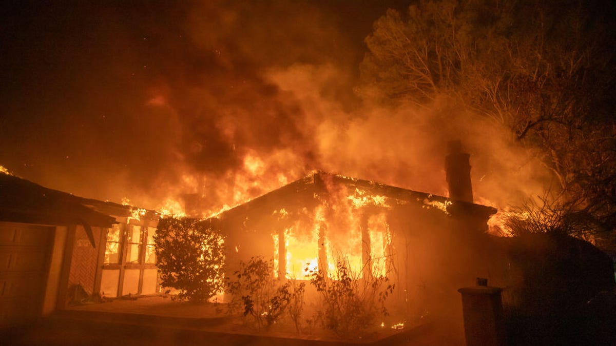Wildfires burn on hills near California homes.