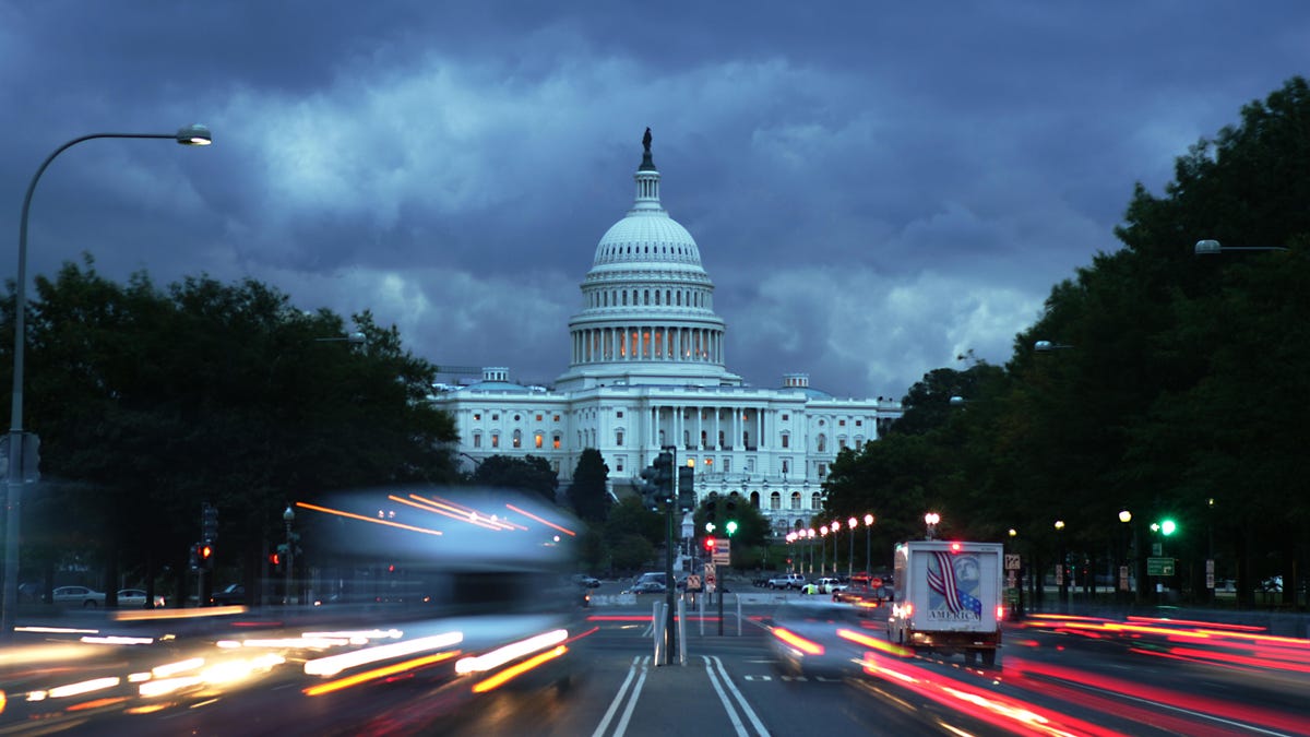 The US Capitol and a street leading up to it, with blurred car headlights and taillights