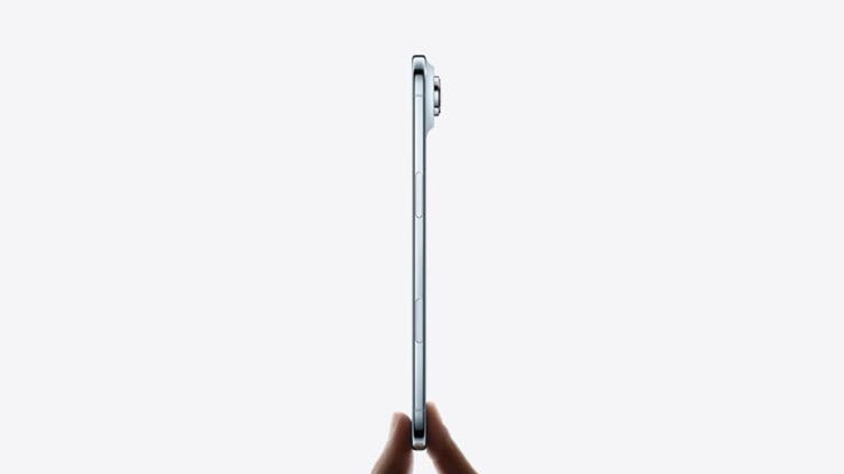 Fingers hold an iPhone Air sideways against a white background.