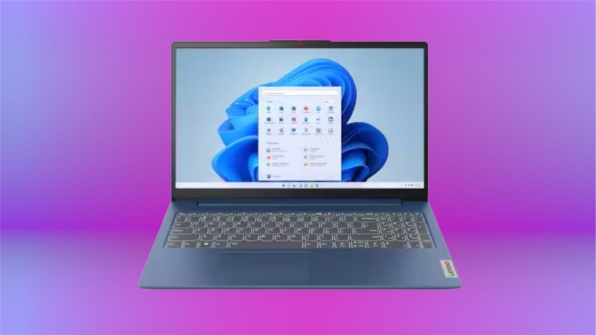 Charcoal grey laptop with blue wallpaper against purple gradient background.