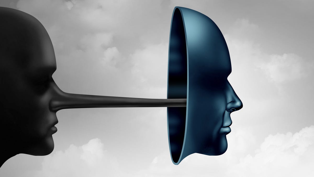 A face with a Pinocchio-like nose tries to hide behind a mask.