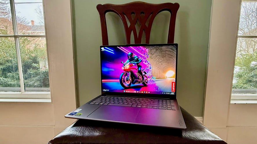 Lenovo Yoga Pro 9i 16 Aura Edition laptop sitting on a dining room chair between two windows