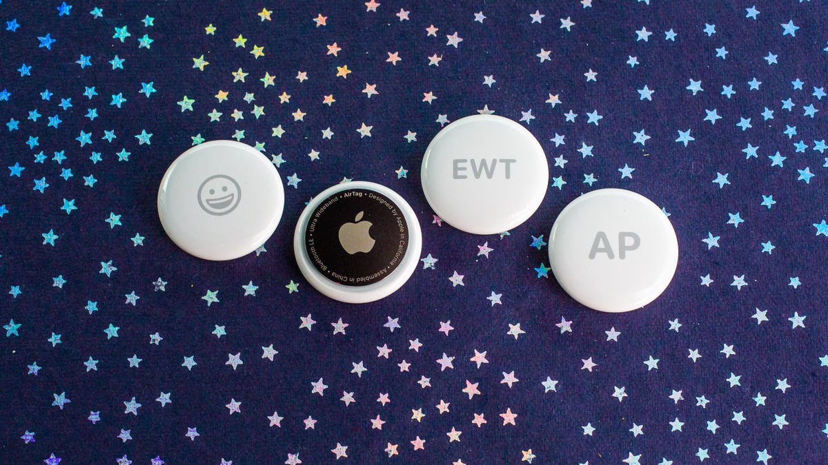 four round apple airtags with different engravings, including the initials AP and a happy face emoji