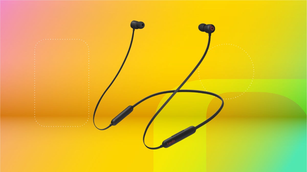 Pair of Black BeatsFlex connected through a wire against coral, yellow and mint CNET gradient.