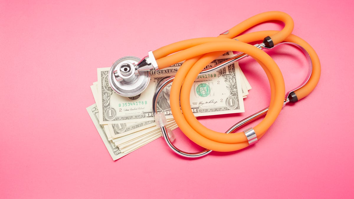 A stethoscope on top of dollar bills