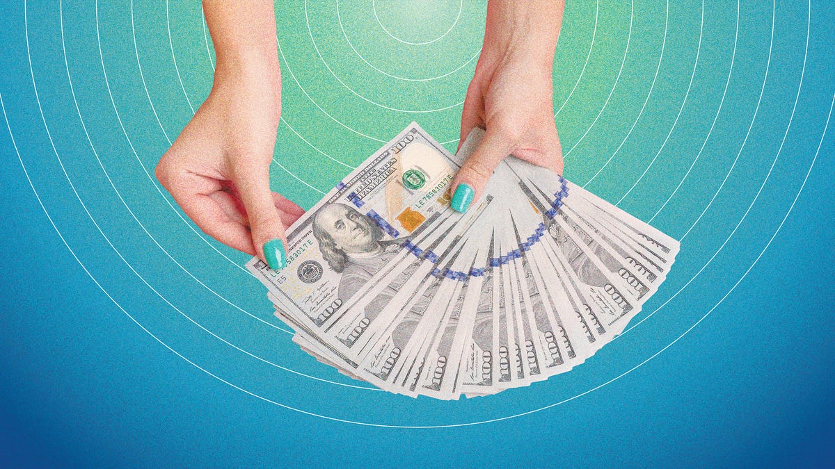 a set of hands fanning dollar bills, in front of a blue and green background
