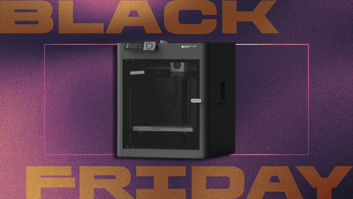 Black Friday promotional graphic featuring black 3D printer with digital display and transparent front panel, enclosed in pink outline. Set against dark purple and pink gradient background with bold metallic orange ‘Black Friday’ text.