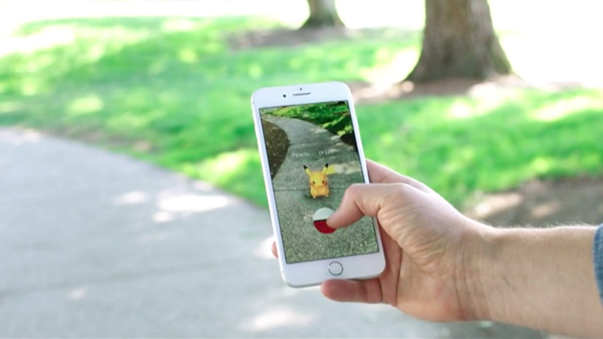 a phone with the game Pokemon Go outdoors in a park