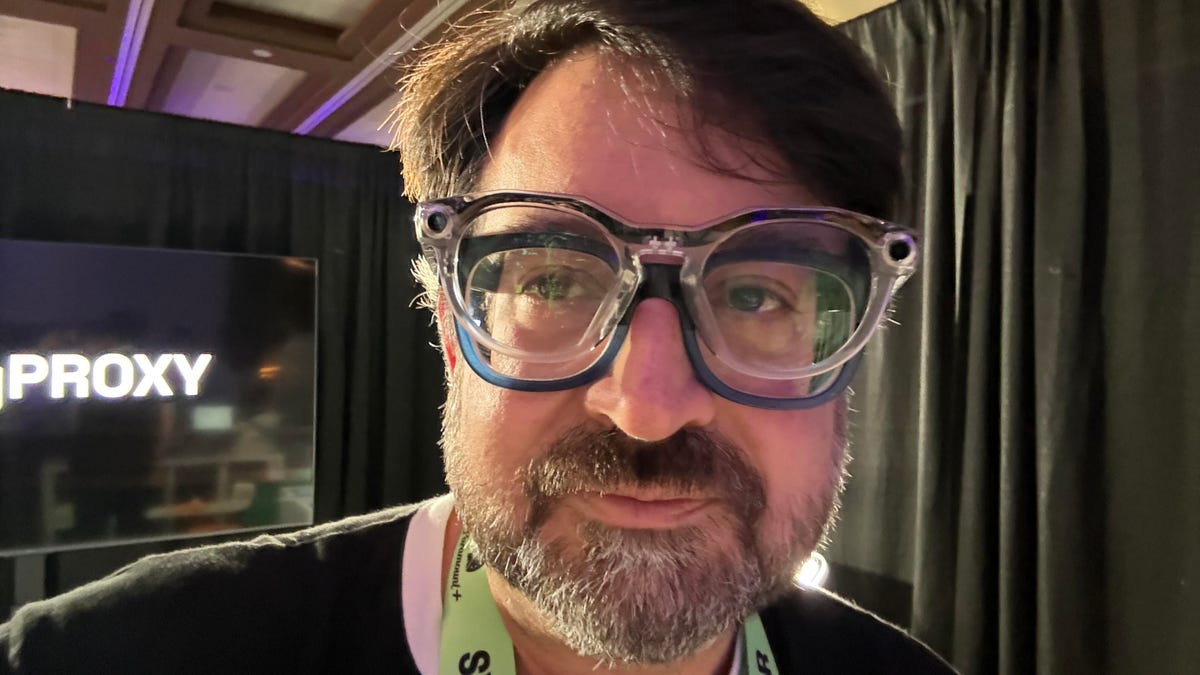 CNET editor Scott Stein wearing smart glasses over his own glasses at SXSW