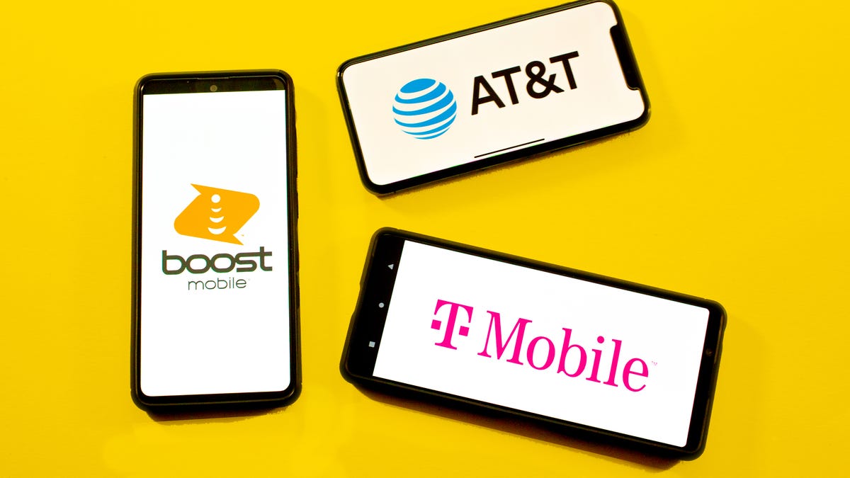 Logos for Boost Mobile, AT&T and T-Mobile on three smartphones against a yellow background