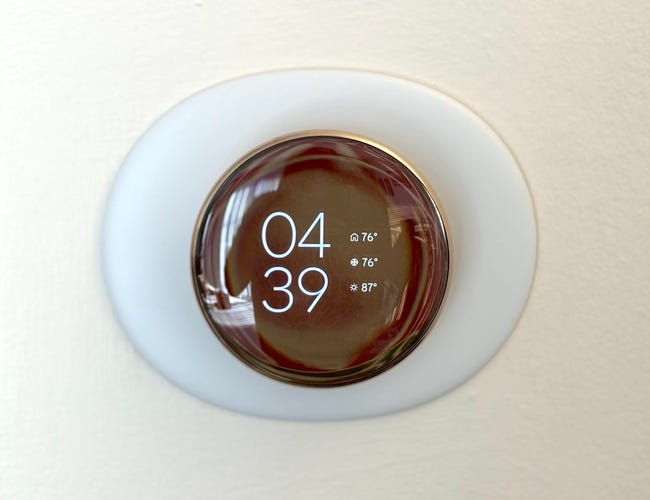 A round thermostat display showing the time and temperatures.