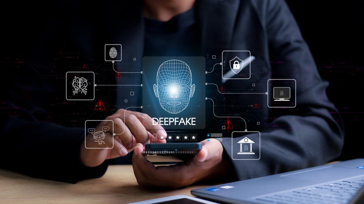 A man using a phone with hologram of a head with the word deepfake below