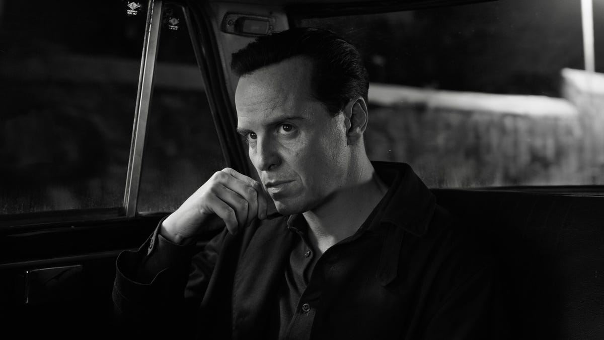 man sitting in car with hand resting on chin