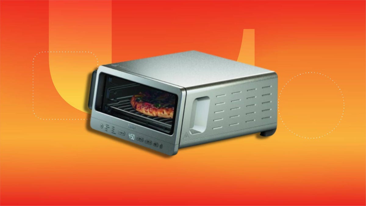 A toaster oven on a bright orange background