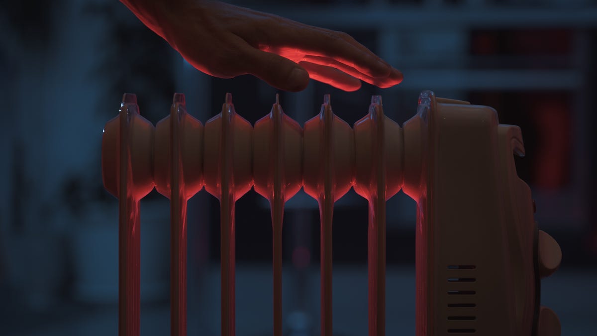 Hand over a heating radiator in a darkish room.