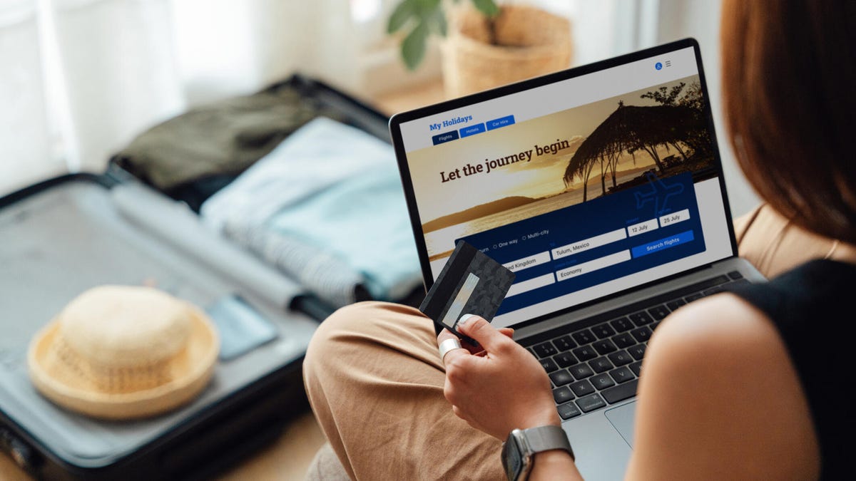woman holding credit card browsing travel site