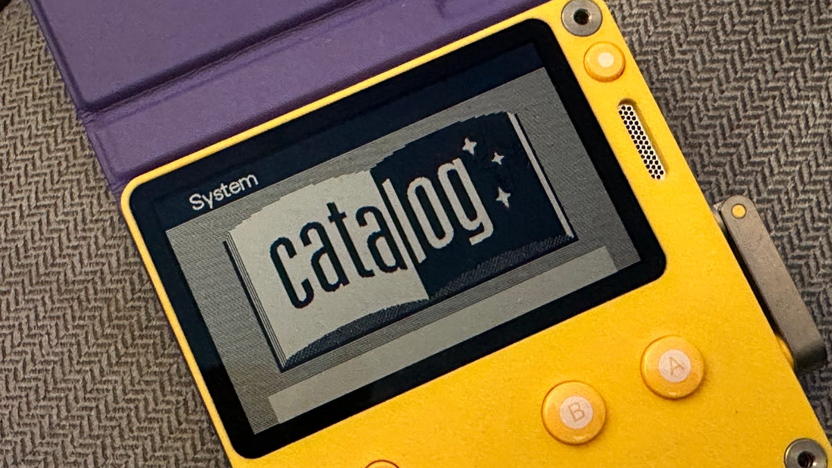 Panic Playdate game handheld sitting on a gray sofa