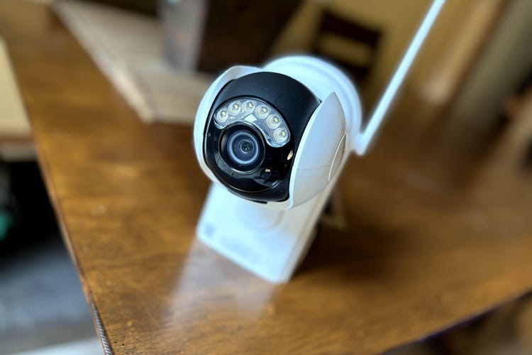 A Reolink Argus PR Ultra cam sits on a wooden table.