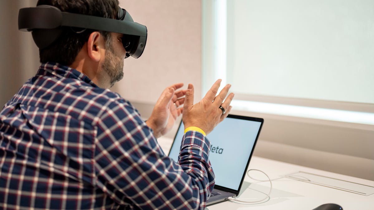 Quest Pro VR headset, being worn while sitting at a desk