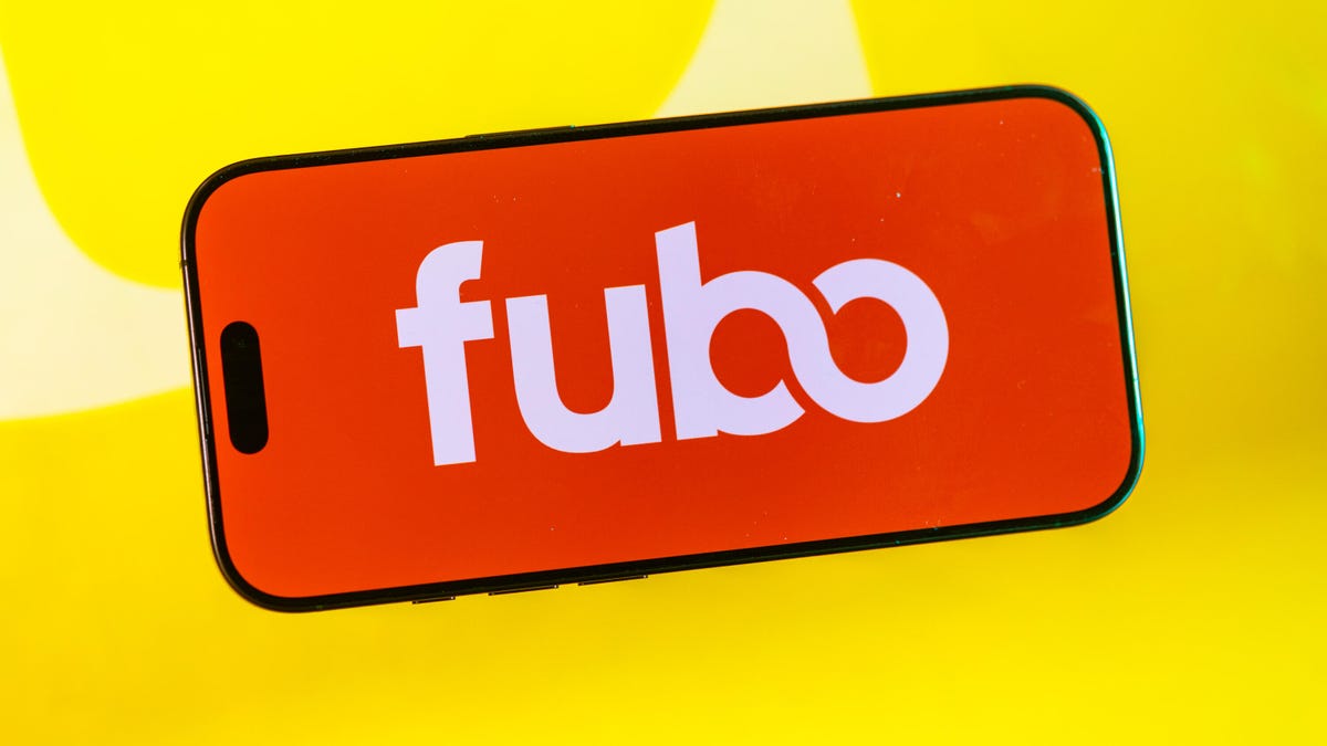 The Fubo logo on a cell phone on a yellow background.