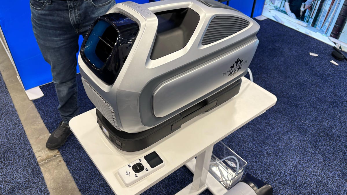 A gray portable air conditioner on a table above a convention center floor.
