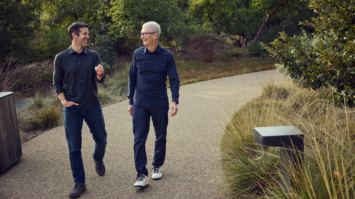 John Ternus (left) and Tim Cook (right) walking outside Apple Park