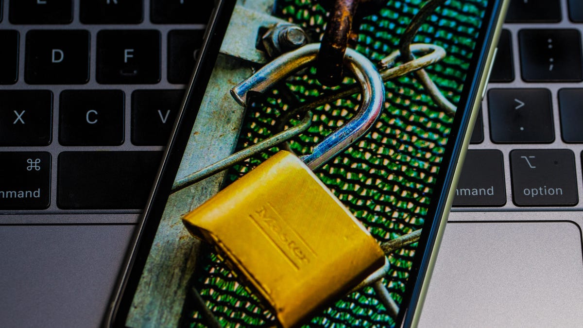 Padlock on smartphone on laptop keyboard