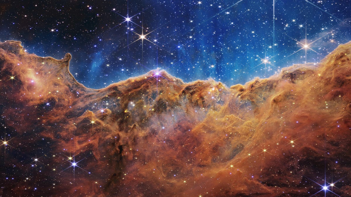 Carina Nebula: Stars sparkle against an indigo backdrop over rusty bronze gas clouds