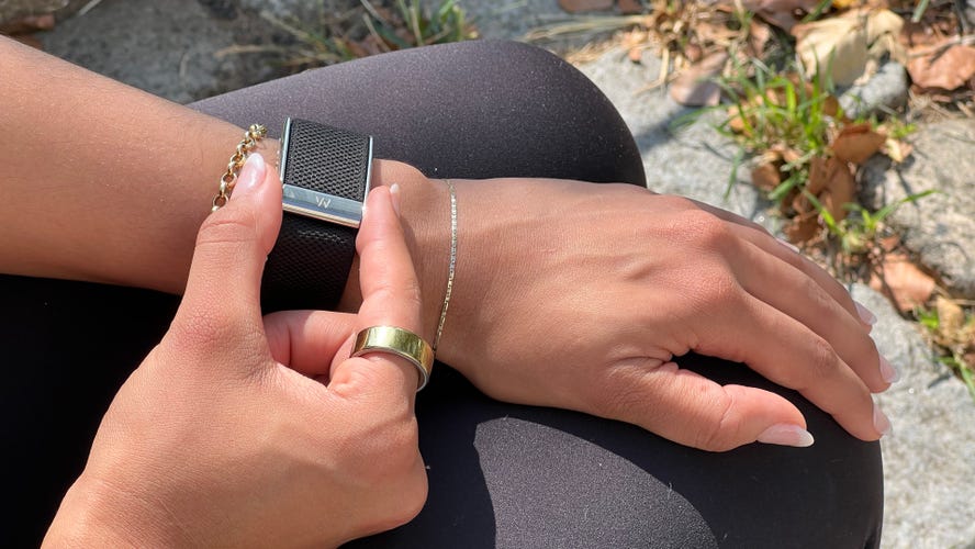 A person adjusting the Whoop 5.0 on their wrist.