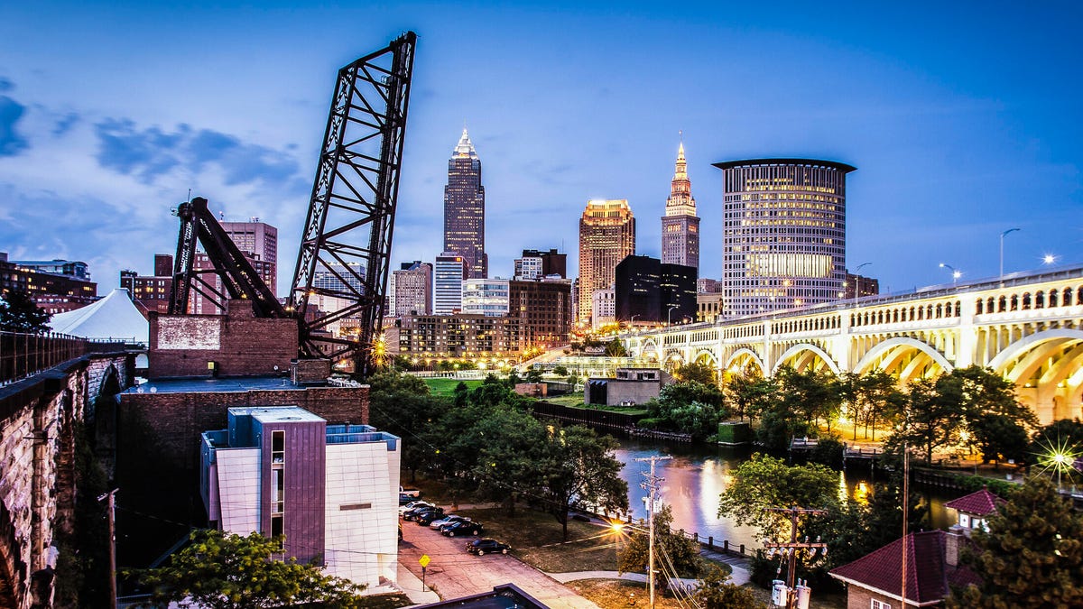 The Cleveland skyline seen from the west side of the Cuyahoga River, with bridges in the foreground.