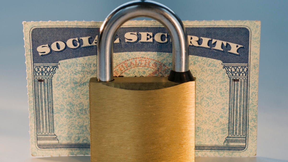 a padlock sits in front of a Social Security card.