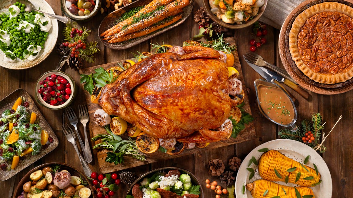 A roast turkey surrounded by Thanksgiving side dishes, seen from above