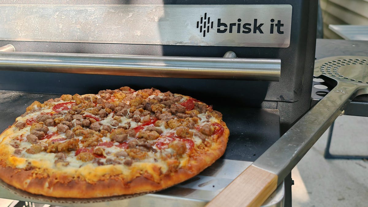 Cooked frozen pizza sitting on the pellet grills shelf.