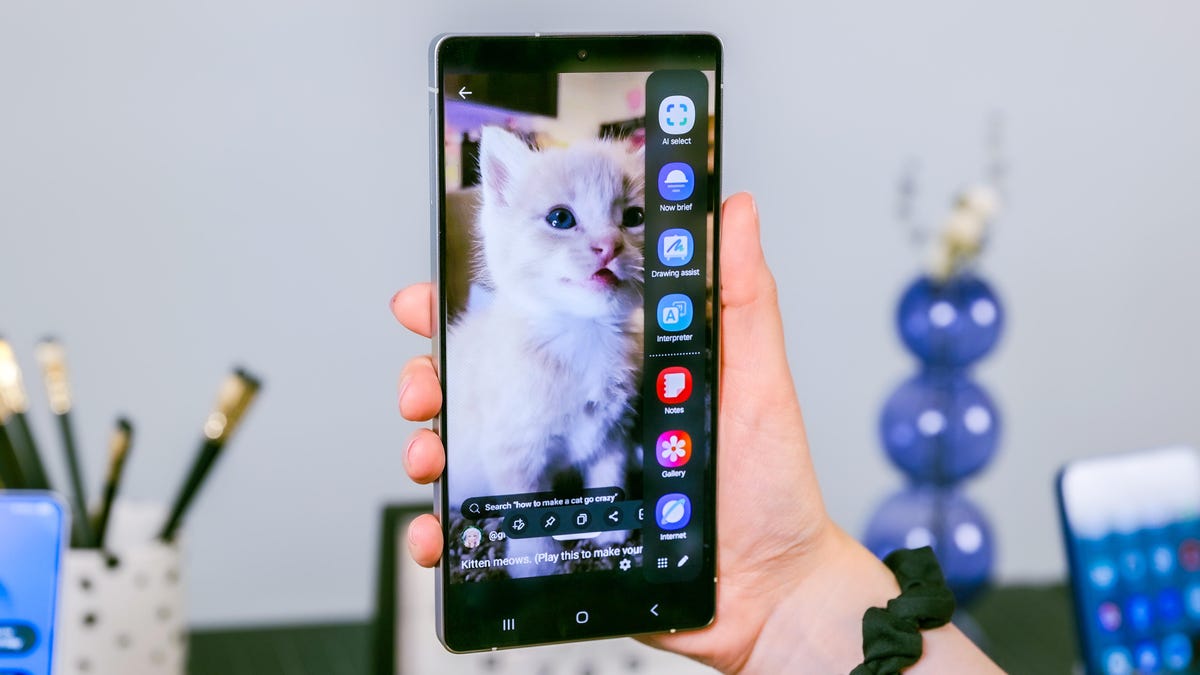 A hand holding the Galaxy S25 Ultra with an image of a cat on the screen