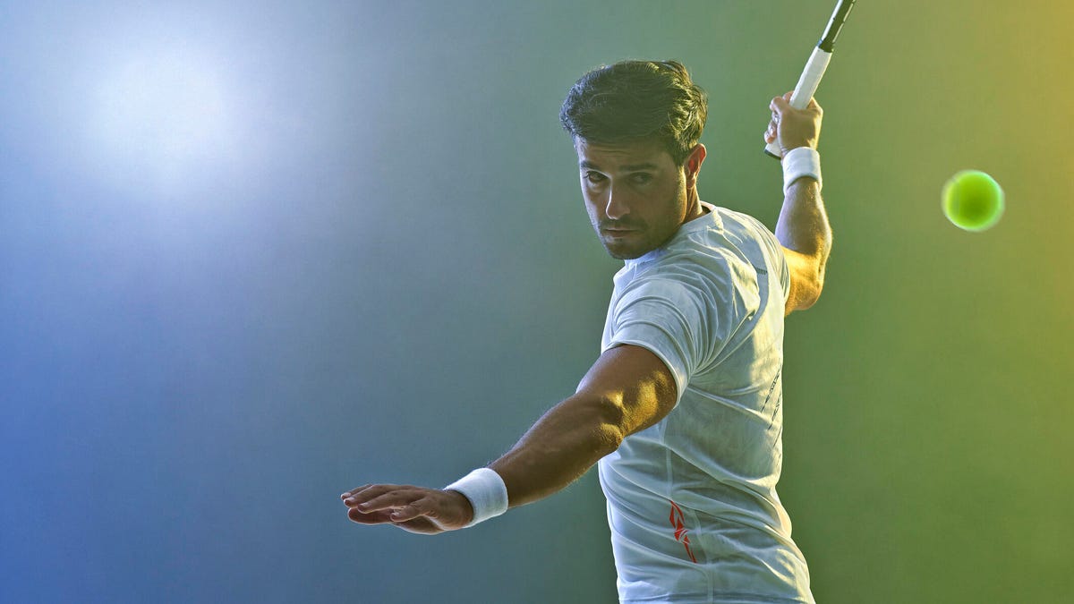 A man prepares to hit a tennis ball with his forehand swing.