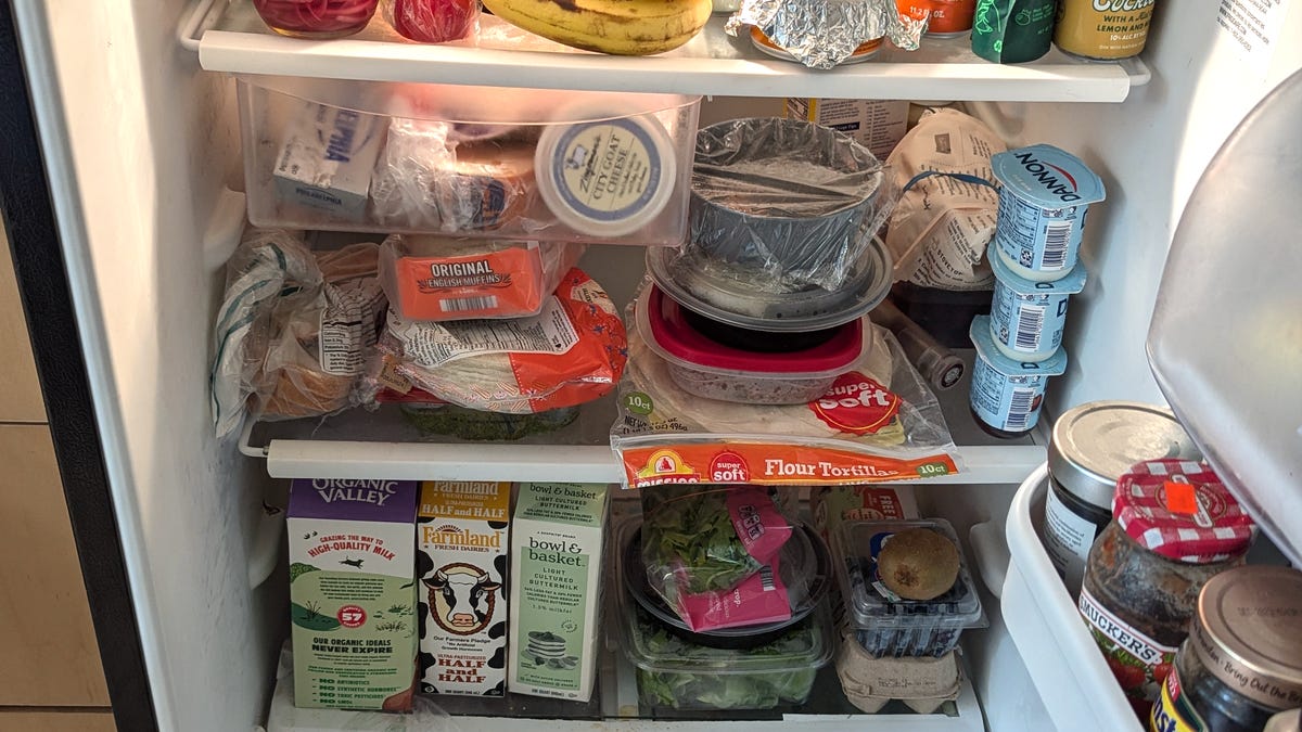 a crowded fridge full of groceries