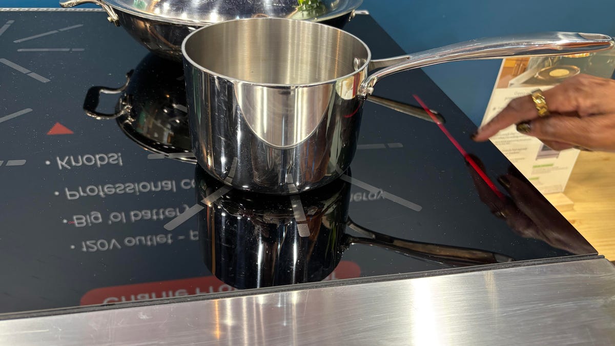 A silver pot of water on a stovetop.