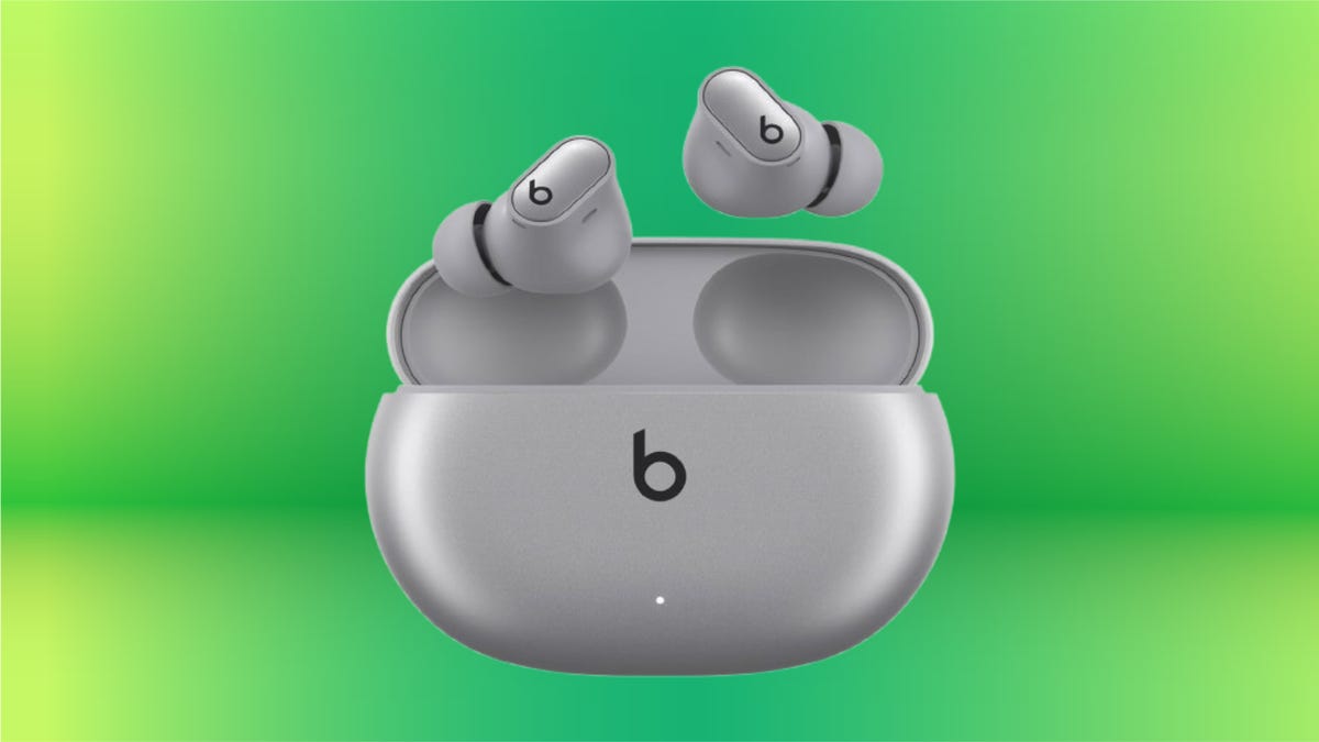 Silver Beats earbuds and case against green gradient background