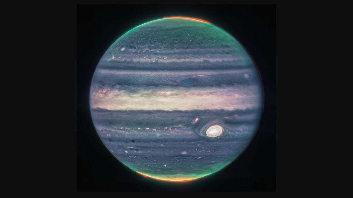 Jupiter appears in swirling shades of blue and purples and white with the Great Red Spot storm looking more like a great white spot.