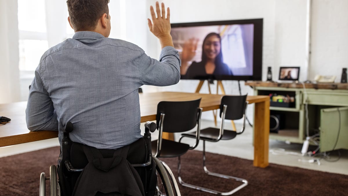 Man in wheelchair talks to woman via video call