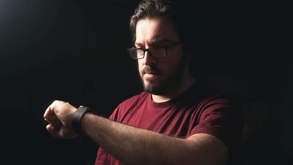 A man looks at a smartwatch.